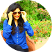 girl in a blue top posing for the camera while wearing black sunglasses