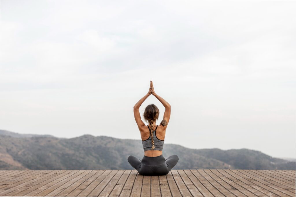 back view woman doing yoga outdoors 1